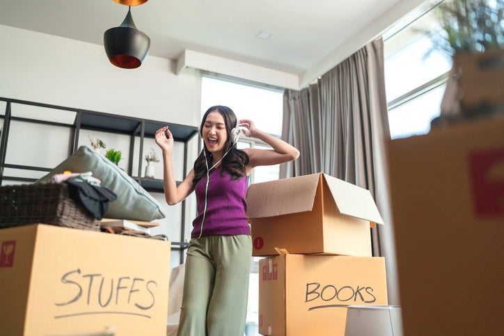 Woman packing boxes and listening to music at home in Capitola, CA